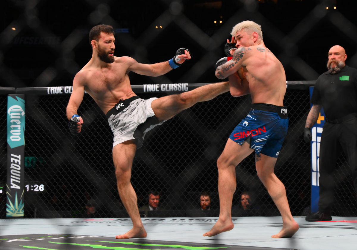 Feb 22, 2025; Seattle, Washington, USA; Ricky Simon (red gloves) fights Javid Basharat (blue gloves) in the bantamweight bout during UFC Fight Night at Climate Pledge Arena. Mandatory Credit: Steven Bisig-Imagn Images