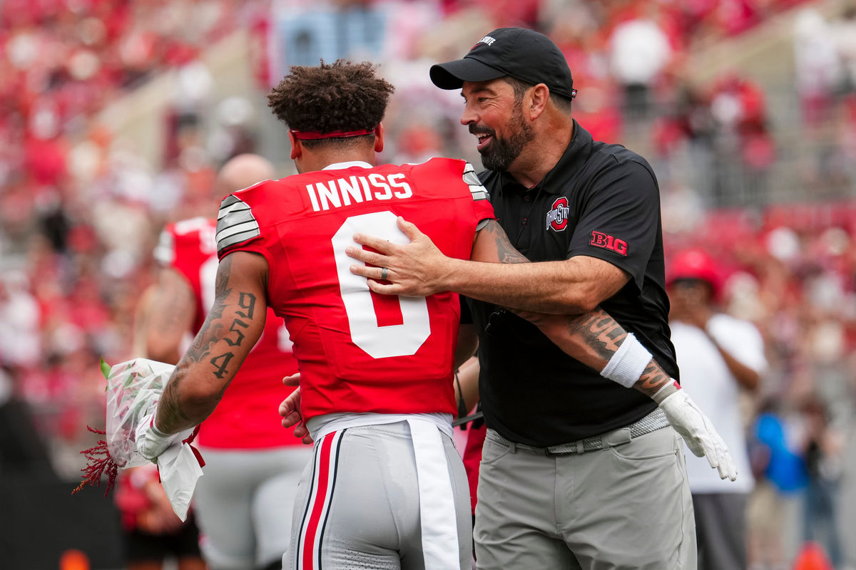 As part of Senior Day recognition, Ohio State Buckeyes head coach Ryan Day hugs wide receiver Brandon Inniss (0) during the NCAA football game against the Ball State Cardinals at Ohio Stadium in Columbus on Sept. 5, 2026. Ohio State won 56-3.