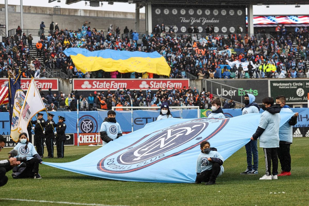 Mar 12, 2022; New York, New York, USA; New York City FC fans display a Ukrainian flag and team logo flag before  game against CF Montreal at Yankee Stadium. Mandatory Credit: Vincent Carchietta-Imagn Images