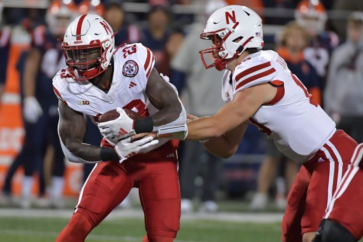 Oct 6, 2023; Champaign, Illinois, USA; Nebraska Cornhuskers quarterback Heinrich Haarberg (10) hands the ball to running back Anthony Grant (23) during the first half against the Illinois Fighting Illini at Memorial Stadium.