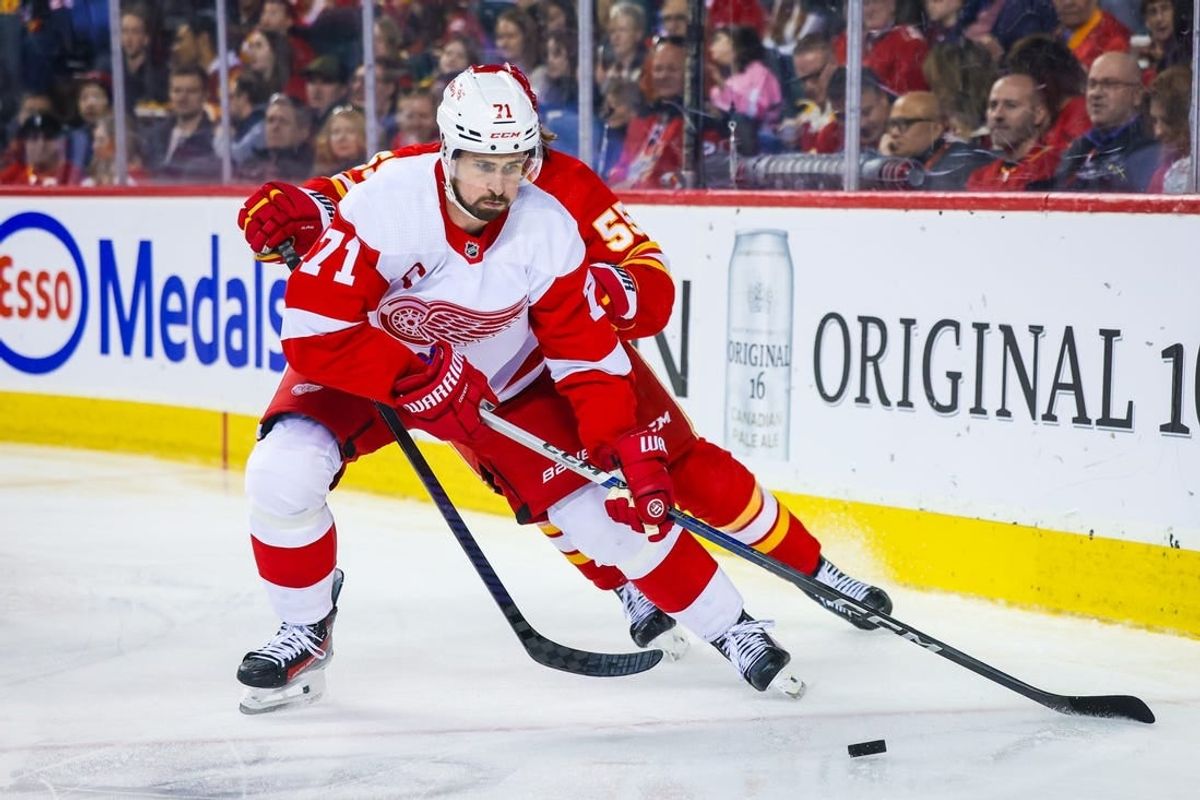 Feb 17, 2024; Calgary, Alberta, CAN; Detroit Red Wings center Dylan Larkin (71) and Calgary Flames defenseman Noah Hanifin (55) battles for the puck during the second period at Scotiabank Saddledome.