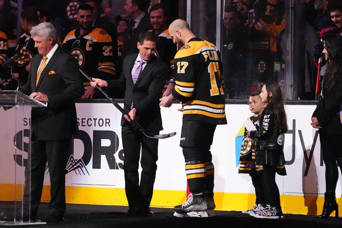 Apr 2, 2022; Boston, Massachusetts, USA; Boston Bruins general Manager Don Sweeney presents Boston Bruins left wing Nick Foligno (17) with a sliver stick to commemorate him playing 1000 games prior to the game against the Columbus Blue Jackets at TD Garden. Mandatory Credit: Gregory Fisher-Imagn Images