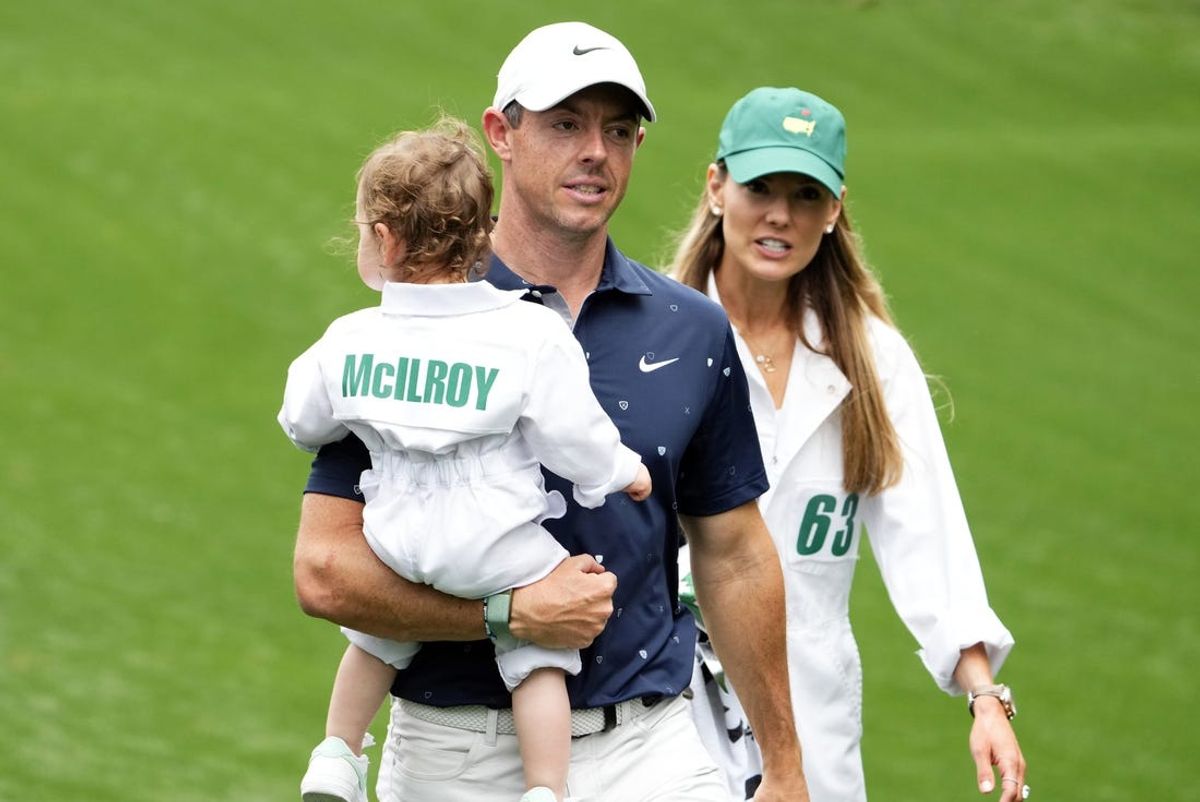 Apr 6, 2022; Augusta, Georgia, USA;  Rory McIlroy holds his daughter Poppy and walks with his wife Erica after finishing the Par 3 Contest at The Masters golf tournament at Augusta National Golf Club. Mandatory Credit: Rob Schumacher-USA TODAY Sports