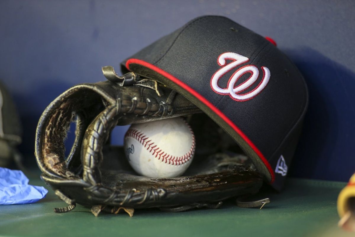 Apr 11, 2022; Atlanta, Georgia, USA; A detailed view of a Washington Nationals hat and glove in the dugout before a game against the Atlanta Braves at Truist Park. Mandatory Credit: Brett Davis-Imagn Images