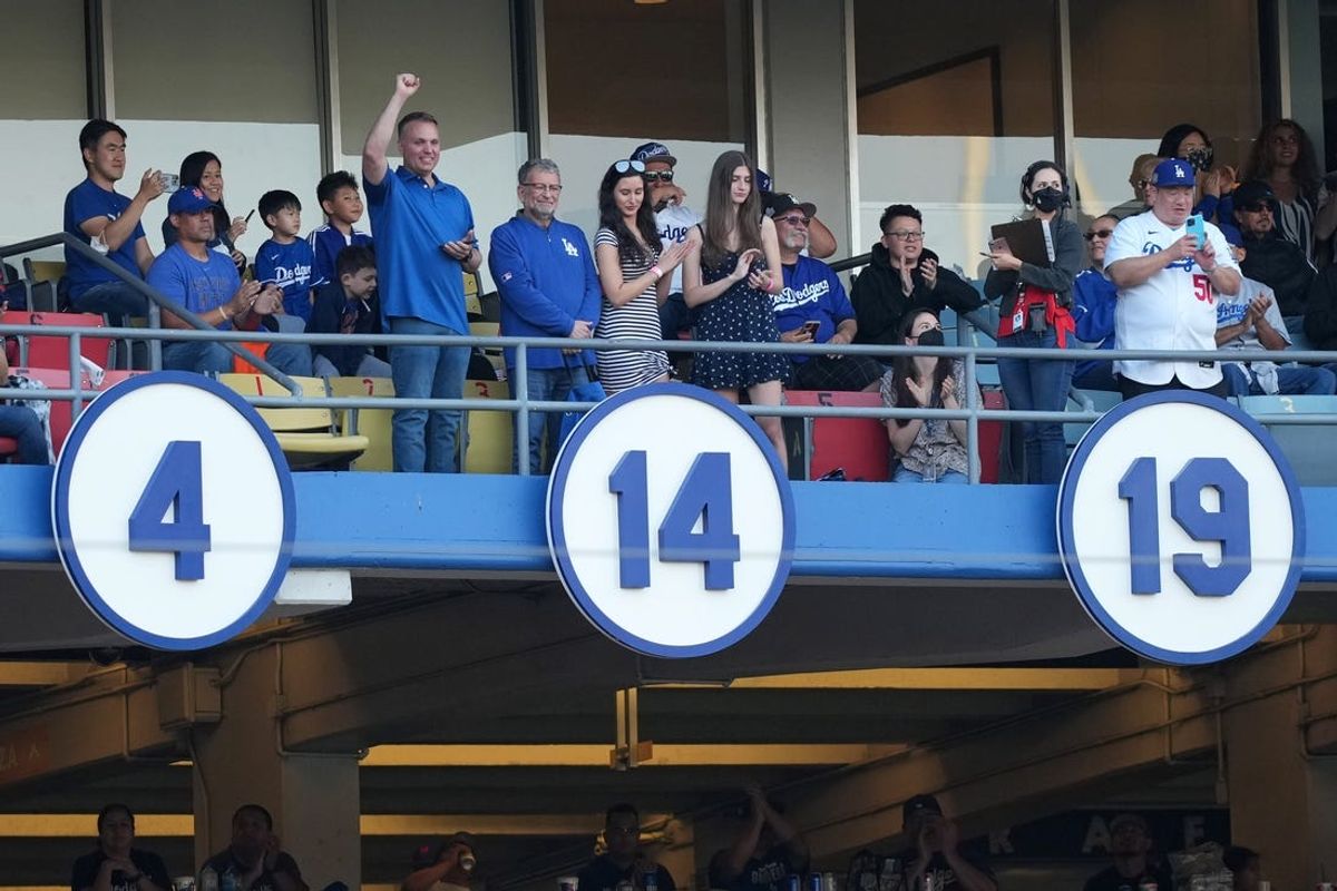 Jun 4, 2022; Los Angeles, California, USA; The retired number of former Brooklyn and Los Angeles Dodgers player Gil Hodges (14) in unveiled on the Dodgers Ring of Honor by grandson Gil Hodges III and Charley Steiner and Hodges great grandchildren before a game against the New York Mets at Dodger Stadium. Mandatory Credit: Kirby Lee-USA TODAY Sports