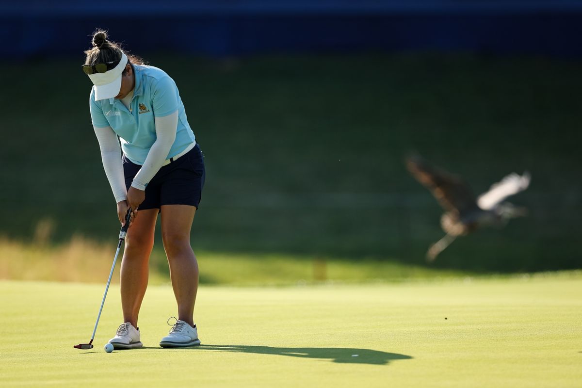 Jun 24, 2022; Bethesda, Maryland, USA; A bird flies behind Jasmine Suwannapura as she putts on the 18th green during the second round of the KPMG Women's PGA Championship golf tournament at Congressional Country Club. Mandatory Credit: Scott Taetsch-Imagn Images