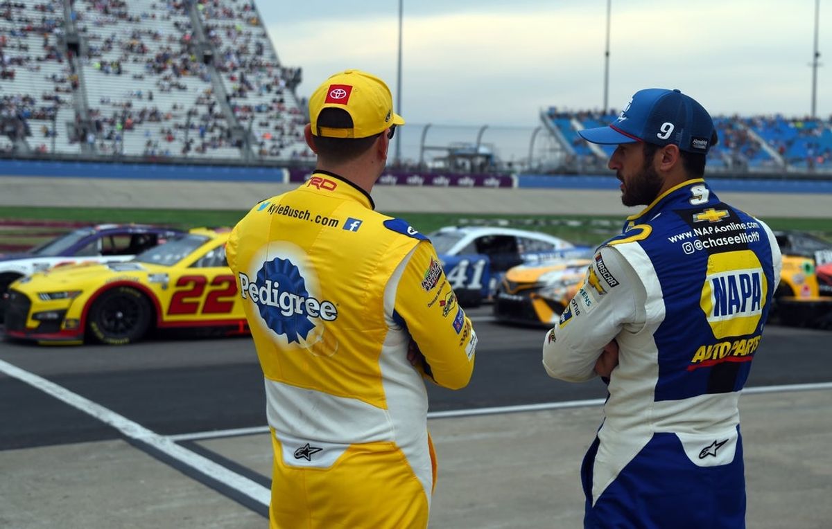Jun 26, 2022; Nashville, Tennessee, USA; NASCAR Cup Series driver Kyle Busch (18) talks with driver Chase Elliott (9) at the end of a weather delay during the Ally 400 at Nashville Superspeedway. Mandatory Credit: Christopher Hanewinckel-Imagn Images