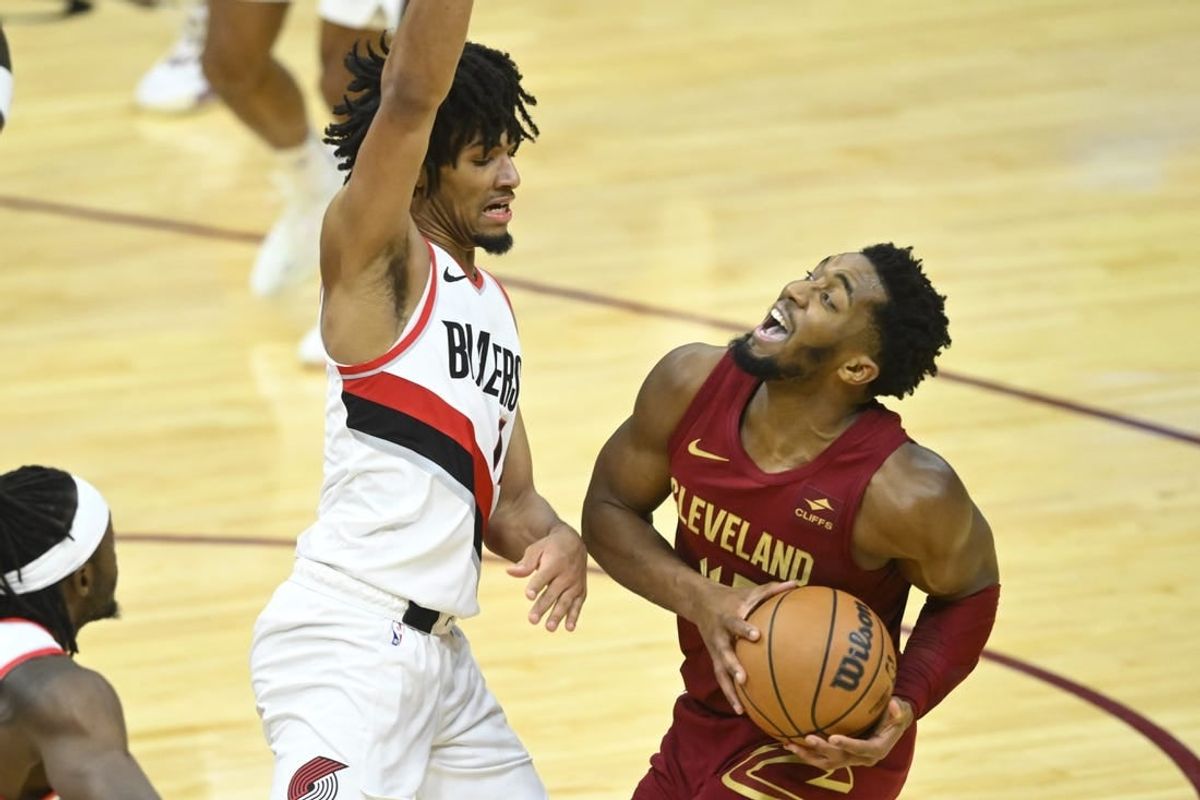 Nov 30, 2023; Cleveland, Ohio, USA; Cleveland Cavaliers guard Donovan Mitchell (45) collides with Portland Trail Blazers guard Shaedon Sharpe (17) in the fourth quarter at Rocket Mortgage FieldHouse.