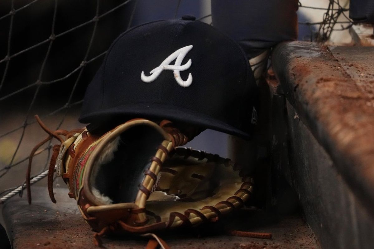 Aug 13, 2022; Miami, Florida, USA; A general view of the cap and glove of Atlanta Braves first baseman Matt Olson (28) on the dugout steps in the ninth inning against the Miami Marlins at loanDepot park. Mandatory Credit: Jasen Vinlove-Imagn Images