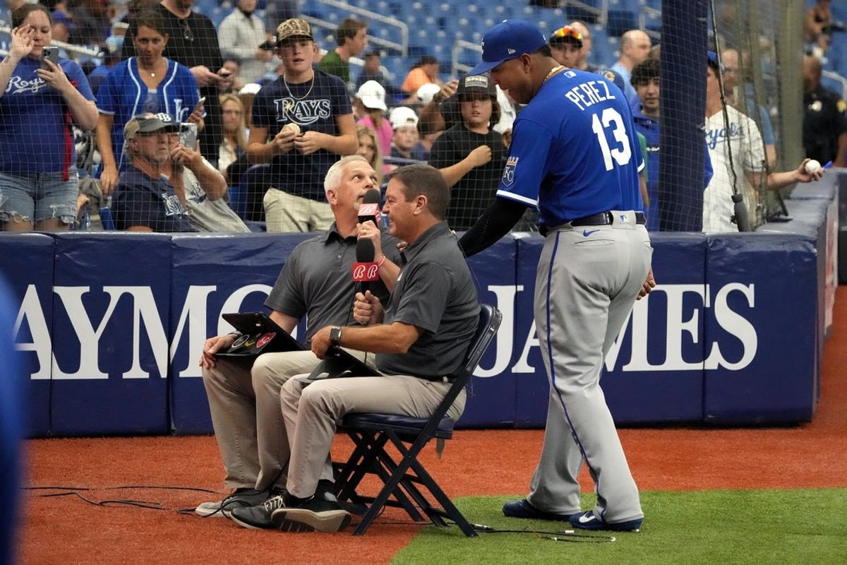 Aug 20, 2022; St. Petersburg, Florida, USA; Kansas City Royals catcher Salvador Perez (13) crashes the Bally Sports live broadcast before today   s game against the Tampa Bay Rays at Tropicana Field. The Bally Broadcasters are Joel Loper (left) and Jeff Montgomery (right). Mandatory Credit: Dave Nelson-Imagn Images
