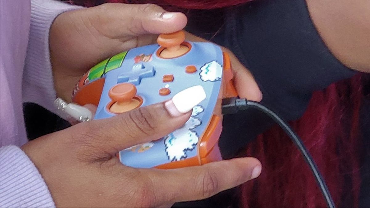 A Pace Center for Girls Jacksonville student uses a controller to play a video game with police after the Sheriff's Office's new mobile gaming center was unveiled at the facility.