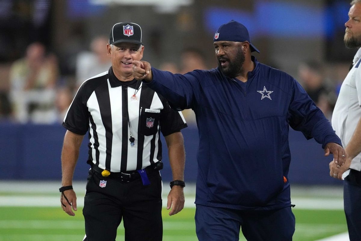 Aug 20, 2022; Inglewood, California, USA; Dallas Cowboys running backs coach Skip Peete (right) talks with line judge referee Jeff Seeman (45) in the second half against the Los Angeles Chargers at SoFi Stadium. Mandatory Credit: Kirby Lee-Imagn Images