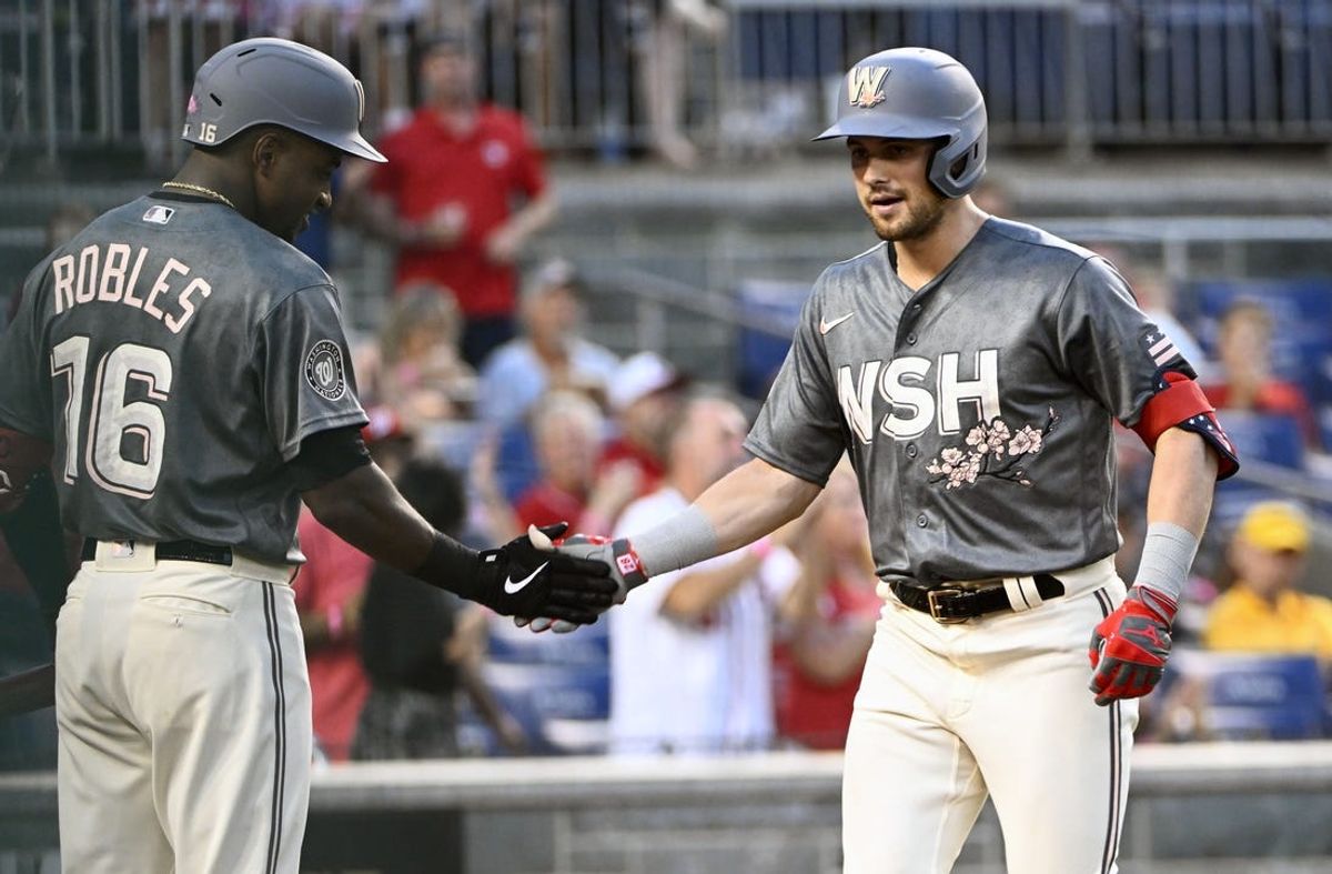 Aug 27, 2022; Washington, District of Columbia, USA; Washington Nationals left fielder Lane Thomas (28) is congratulated by center fielder Victor Robles (16) after hitting a solo home run against the Cincinnati Reds during the second inning at Nationals Park. Mandatory Credit: Brad Mills-USA TODAY Sports