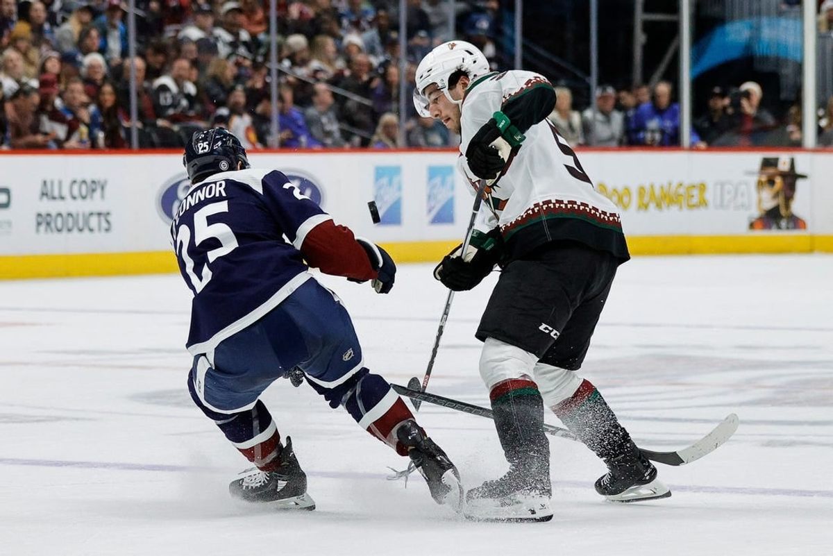 Dec 23, 2023; Denver, Colorado, USA; Colorado Avalanche right wing Logan O'Connor (25) and Arizona Coyotes defenseman Sean Durzi (50) battle for the puck in the third period at Ball Arena.