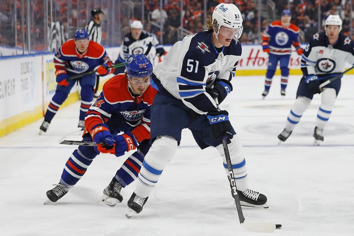 Sep 25, 2022; Edmonton, Alberta, CAN; Winnipeg Jets forward Chaz Lucius (51) makes a pass in front Edmonton Oilers forward Xavier Bourgault (54) during the third period at Rogers Place. Mandatory Credit: Perry Nelson-Imagn Images