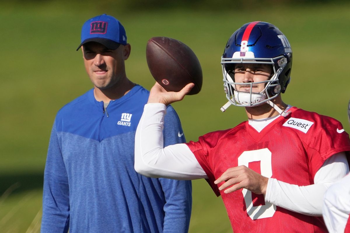 Oct 7, 2022; Thundridge, United Kingdom; New York Giants quarterback Daniel Jones (8) throws the ball as offensive coordinator Mike Kafka watches during practice at Hanbury Manor. Mandatory Credit: Kirby Lee-Imagn Images