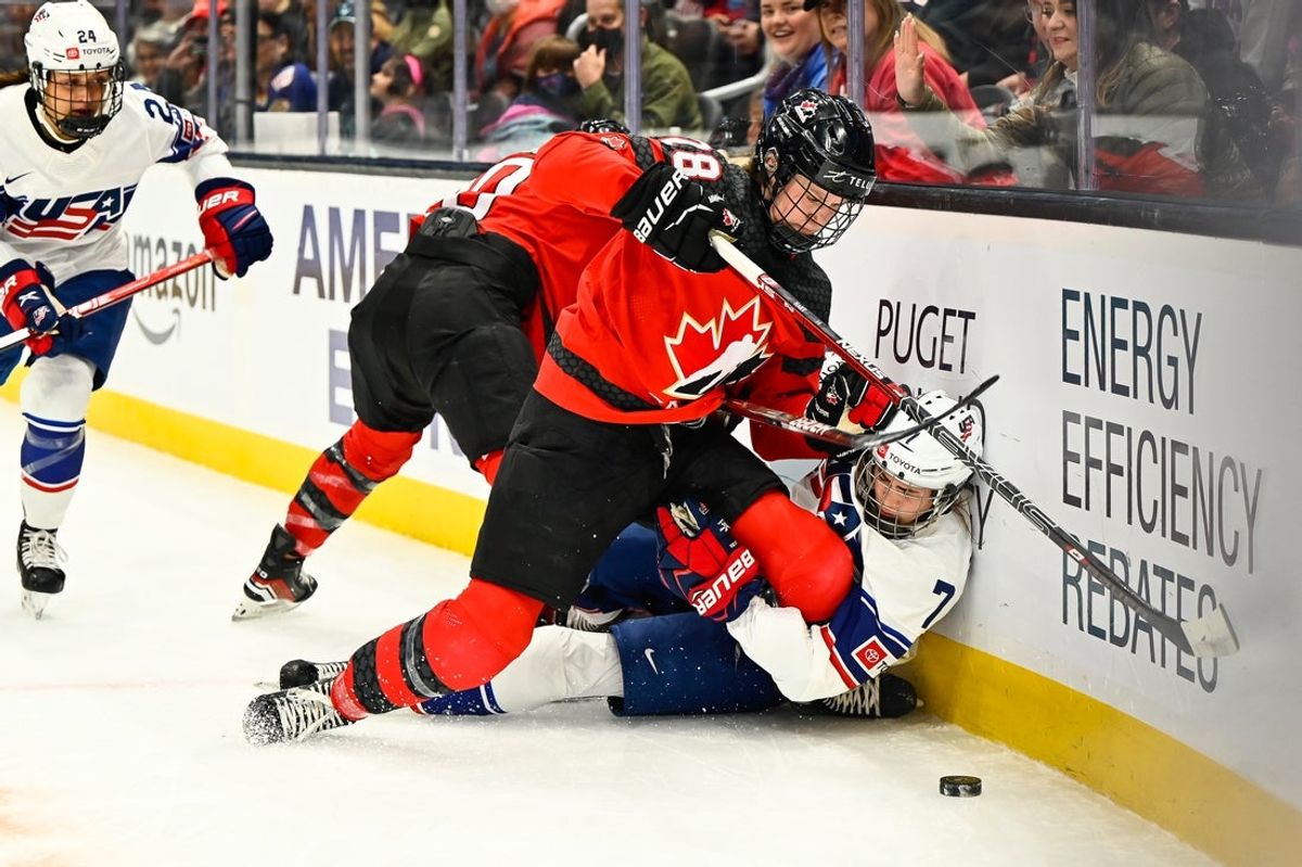 Nov 20, 2022; Seattle, Washington, USA; Canada defenseman Micah Zandee-Hart (28) checks USA  forward Clair DeGeorge (7) into the wall during the first period at Climate Pledge Arena. Mandatory Credit: Steven Bisig-Imagn Images