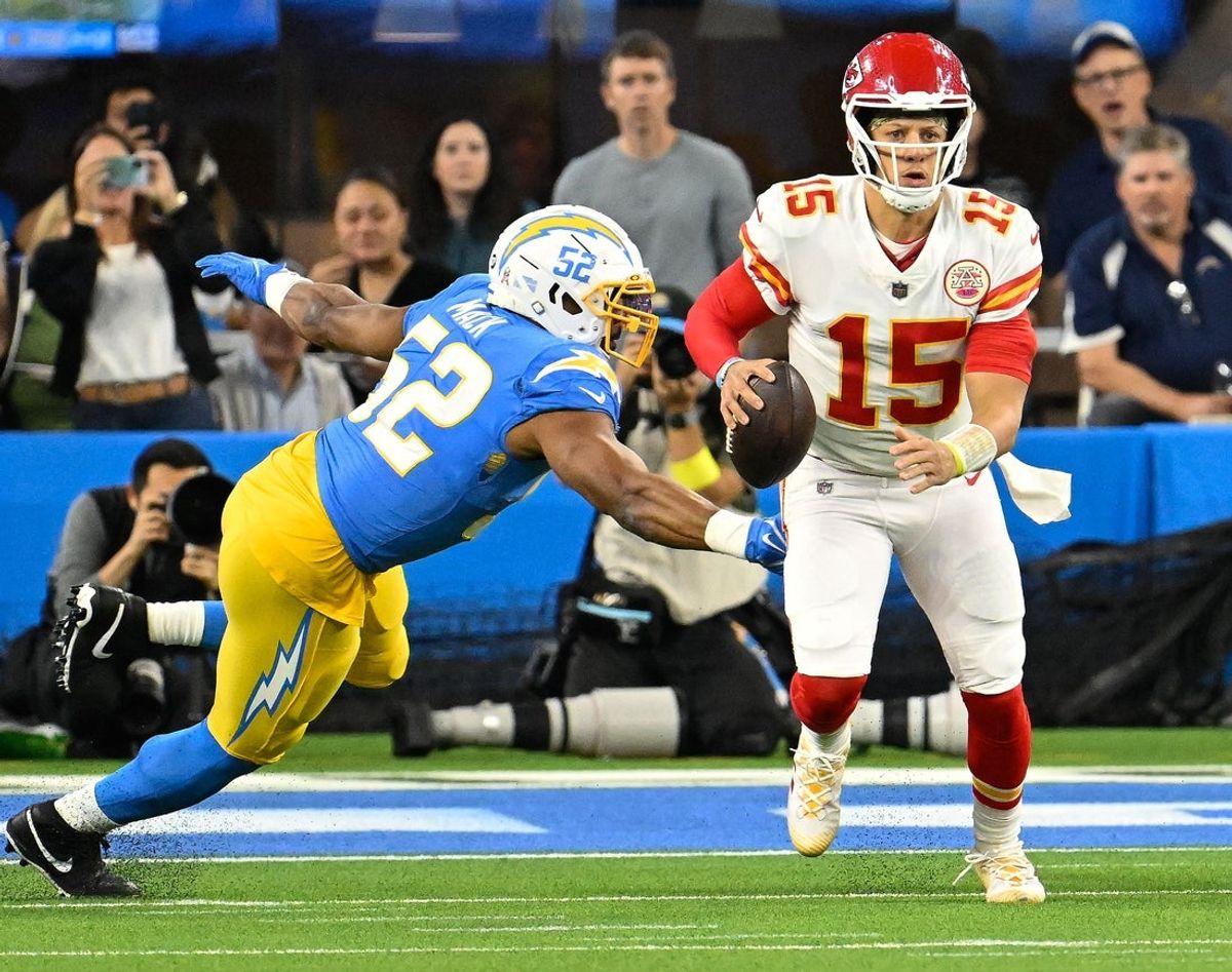 Kansas City Chiefs quarterback Patrick Mahomes (15) scrambles past Los Angeles Chargers linebacker Khalil Mack (52) bring the first quarter at SoFi Stadium. Mandatory Credit: Robert Hanashiro-Imagn Images