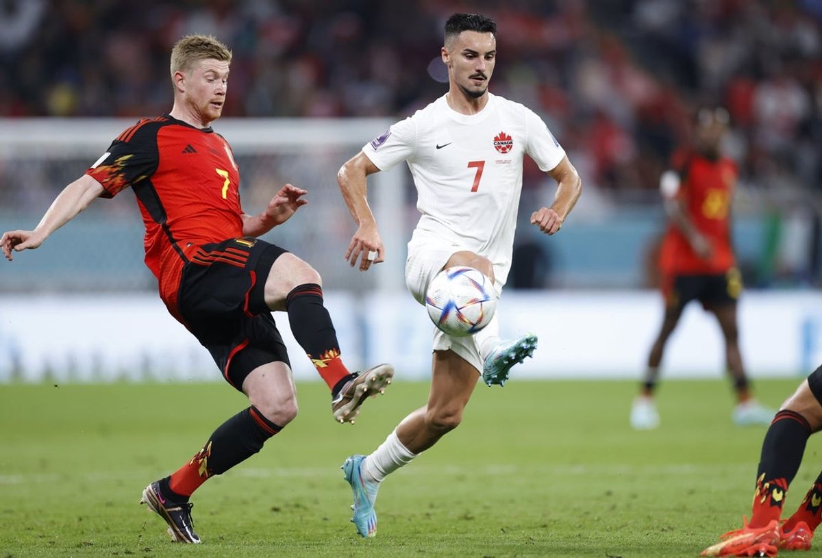 Nov 23, 2022; Al Rayyan, Qatar; Belgium midfielder Kevin De Bruyne (red jersey) and Canada midfielder Stephen Eustaquio battle for control during the first half of a group stage match during the 2022 FIFA World Cup at Ahmad Bin Ali Stadium. Mandatory Credit: Yukihito Taguchi-Imagn Images