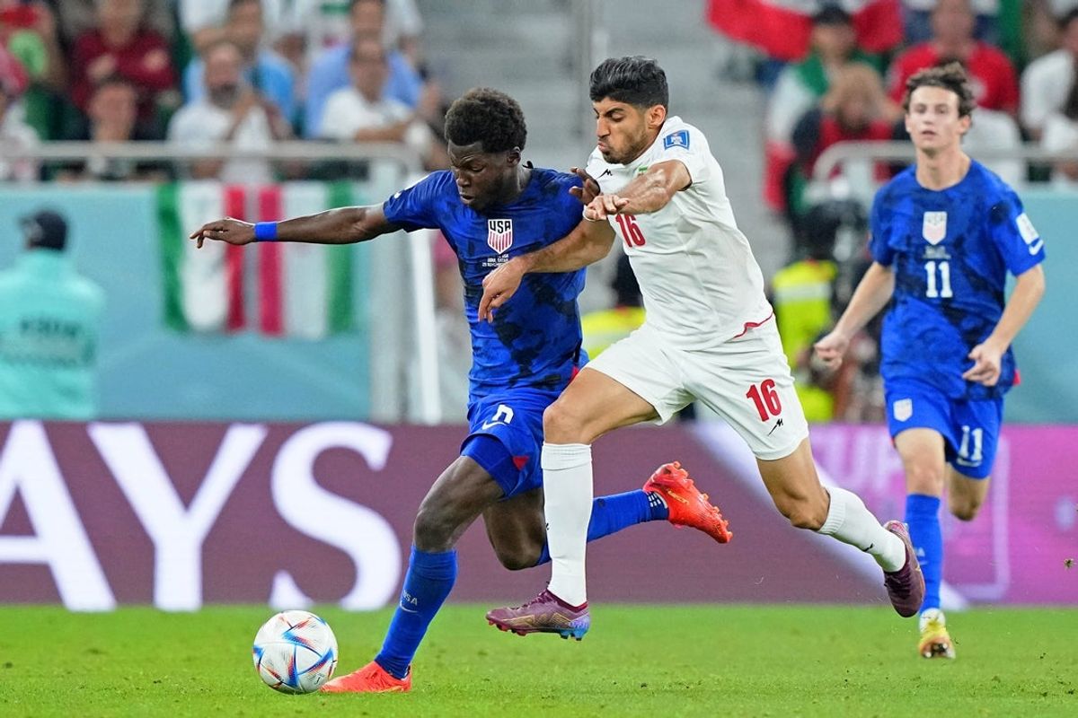 Nov 29, 2022; Doha, Qatar; United States of America midfielder Yunus Musah (6) battles for the ball against Iran midfielder Mehdi Torabi (16) during the second half of a group stage match during the 2022 World Cup at Al Thumama Stadium. Mandatory Credit: Danielle Parhizkaran-Imagn Images