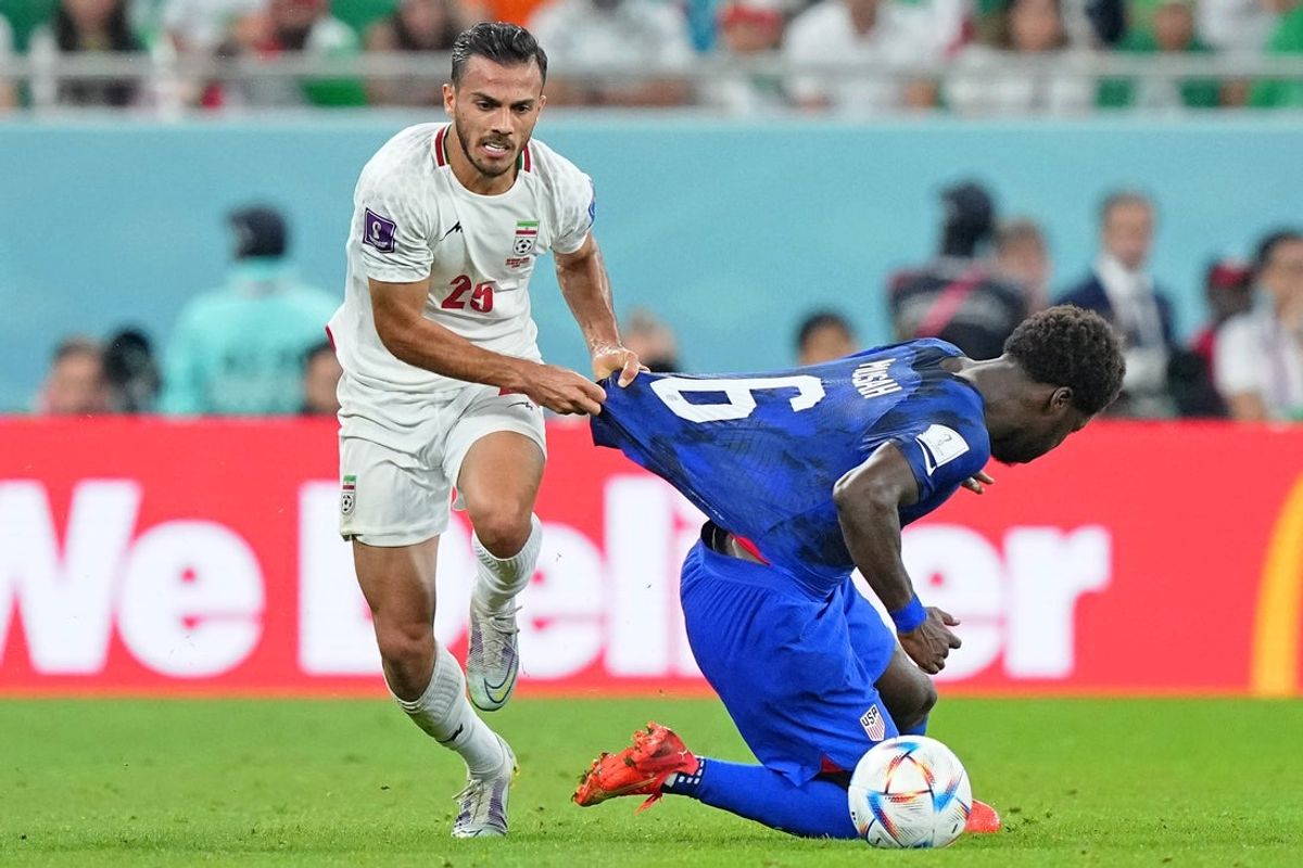 Nov 29, 2022; Doha, Qatar; Iran midfielder Saeid Ezatolahi (6) pulls the jersey of United States of America midfielder Yunus Musah (6) during the second half of a group stage match during the 2022 World Cup at Al Thumama Stadium. Mandatory Credit: Danielle Parhizkaran-Imagn Images