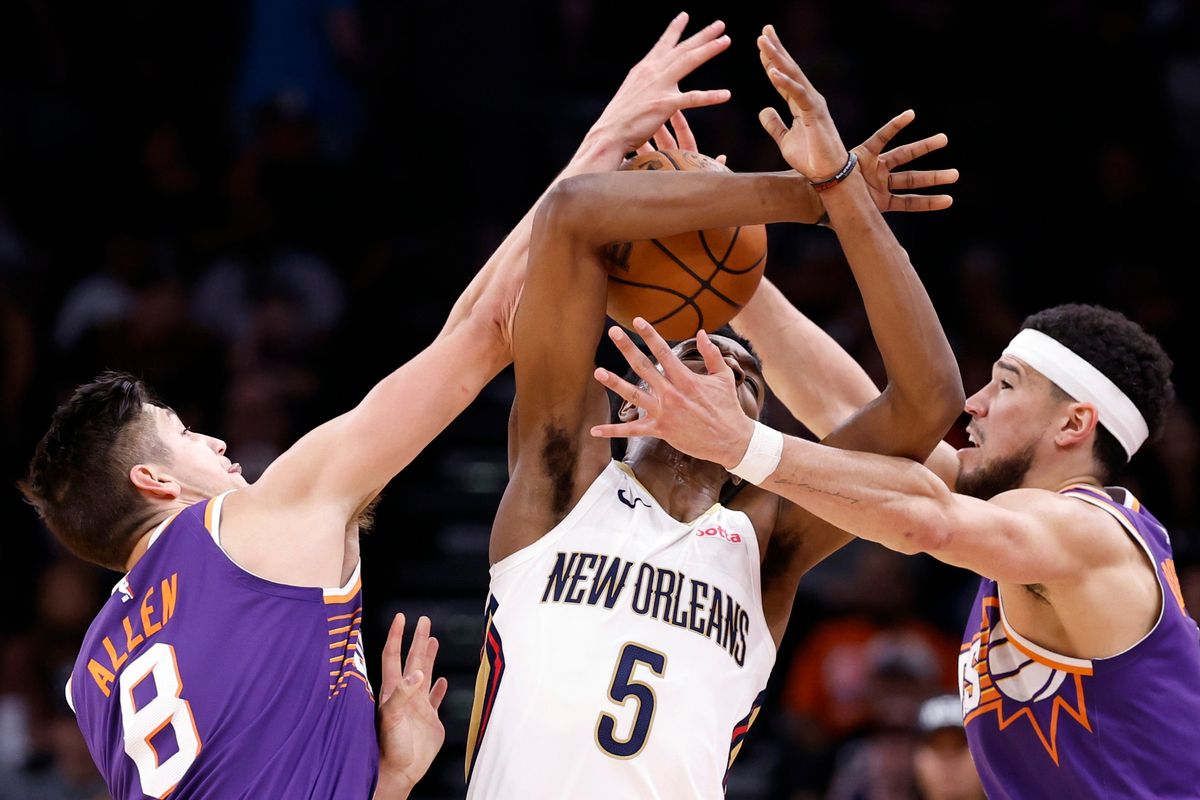 PHOENIX, ARIZONA - 7 DE ABRIL: Grayson Allen #8 y Devin Booker #1 de los Phoenix Suns presionan a Herbert Jones #5 de los New  Orleans Pelicans durante la segunda mitad en Footprint Center el 07 de abril, 2024 en Phoenix, Arizona. NOTA PARA EL USUARIO: El usuario reconoce expresamente y  acepta que, al descargar o usar esta fotografía, el Usuario da su consentimiento a los términos y condiciones del Acuerdo de Licencia de Getty Images.   (Foto de Chris Coduto/Getty Images)