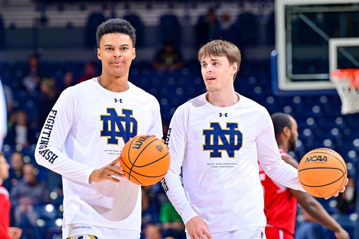 Dec 7, 2022; South Bend, Indiana, USA; Notre Dame Fighting Irish guards Tony Sanders Jr. (12) and Robby Carmody (24) warm up before the game against the Boston University Terriers at the Purcell Pavilion. Mandatory Credit: Matt Cashore-Imagn Images