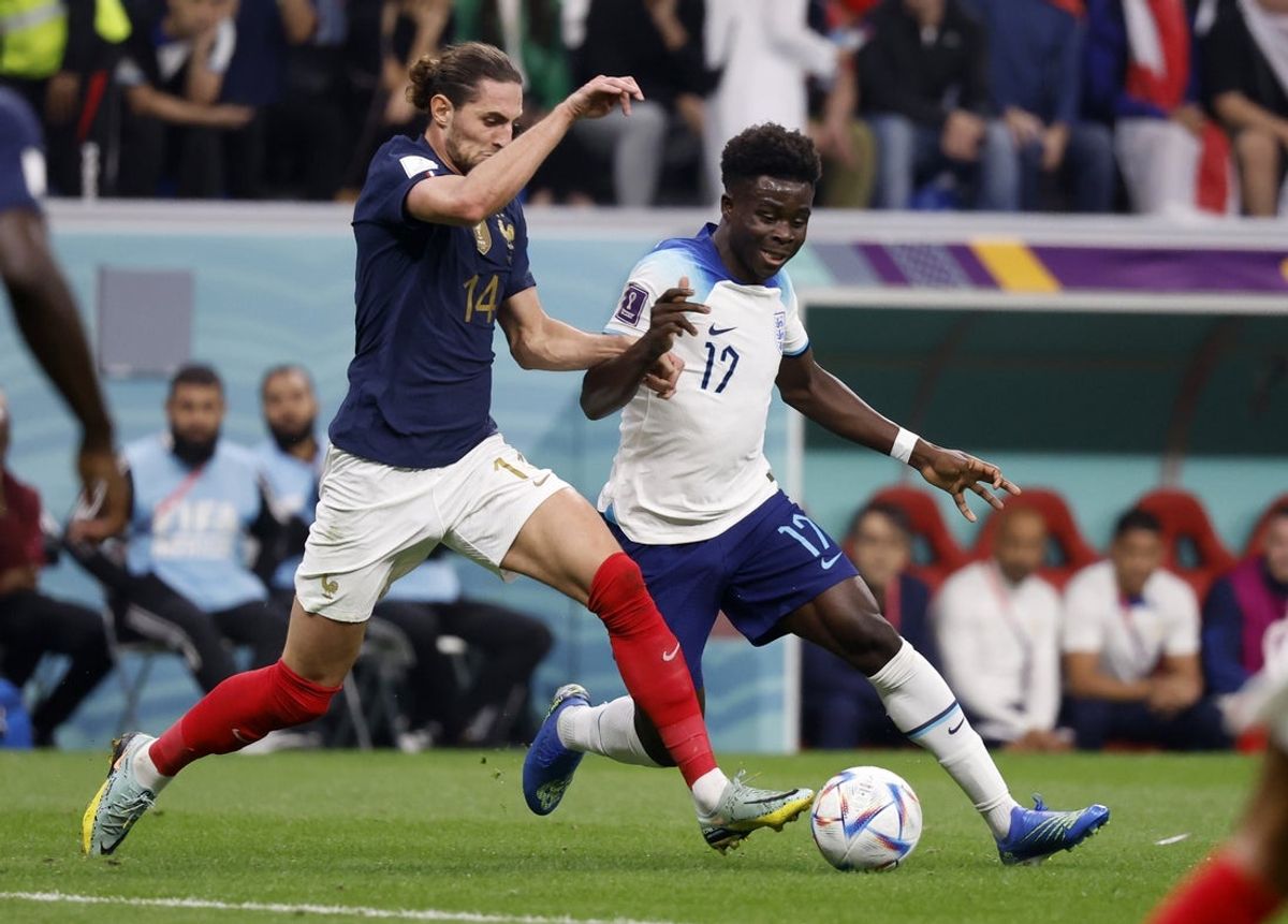 Dec 10, 2022; Al Khor, Qatar; France midfielder Adrien Rabiot (14) and England midfielder Bukayo Saka (17) fight for the ball during the first half of a quarterfinal game in the 2022 FIFA World Cup at Al-Bayt Stadium. Mandatory Credit: Yukihito Taguchi-Imagn Images