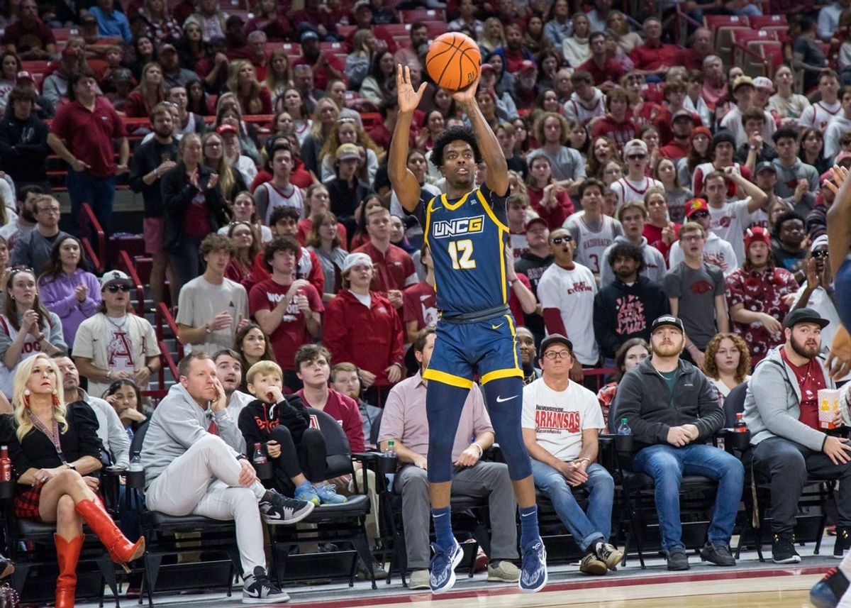 Dec 6, 2022; Fayetteville, Arkansas, USA;  UNC-Greensboro Spartans guard Donovan Atwell (12) shoots the ball during the first half against the Arkansas Razorbacks at Bud Walton Arena. Arkansas won 65-58. Mandatory Credit: Brett Rojo-Imagn Images