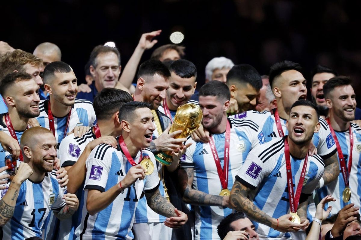 Dec 18, 2022; Lusail, Qatar; Argentina forward Lionel Messi (10) holds the World Cup trophy as he and his teammates celebrate after winning the 2022 World Cup final against France at Lusail Stadium. Mandatory Credit: Yukihito Taguchi-Imagn Images