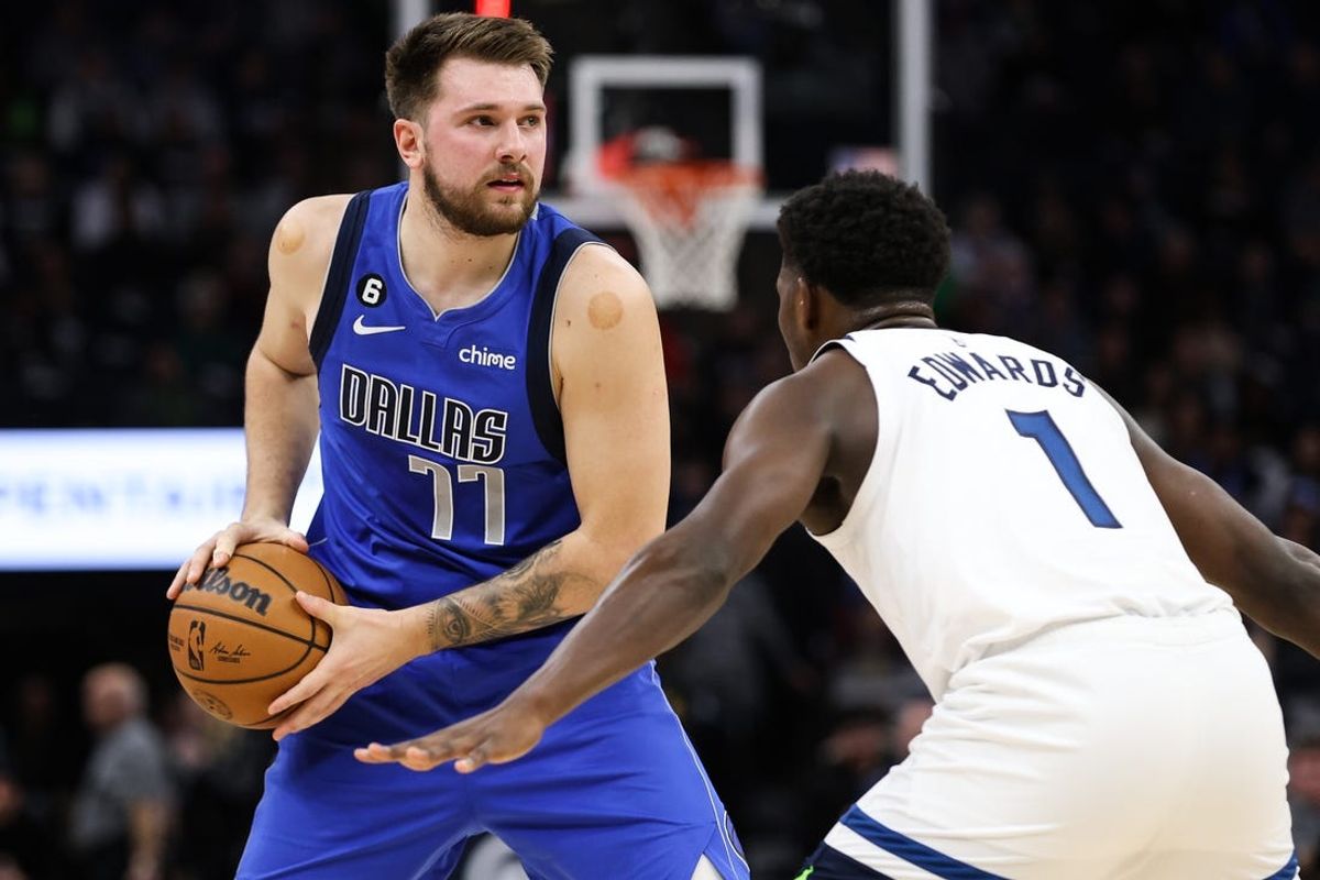 Dec 19, 2022; Minneapolis, Minnesota, USA; Dallas Mavericks guard Luka Doncic (77) looks to pass while Minnesota Timberwolves guard Anthony Edwards (1) defends during the first quarter at Target Center. Mandatory Credit: Matt Krohn-USA TODAY Sports