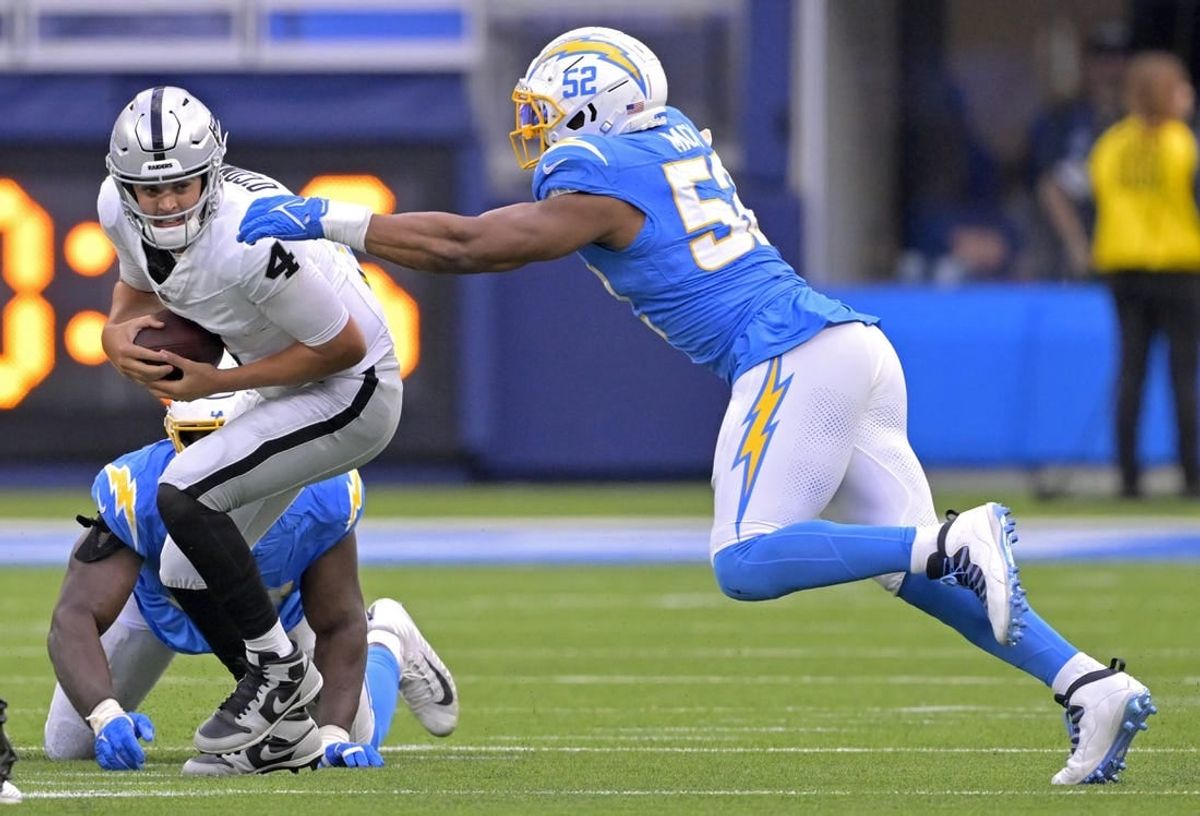 Oct 1, 2023; Inglewood, California, USA;  Las Vegas Raiders quarterback Aidan O'Connell (4) escapes the grasp of Los Angeles Chargers defensive tackle Sebastian Joseph-Day (51) but is sacked by linebacker Khalil Mack (52) in the second half at SoFi Stadium.