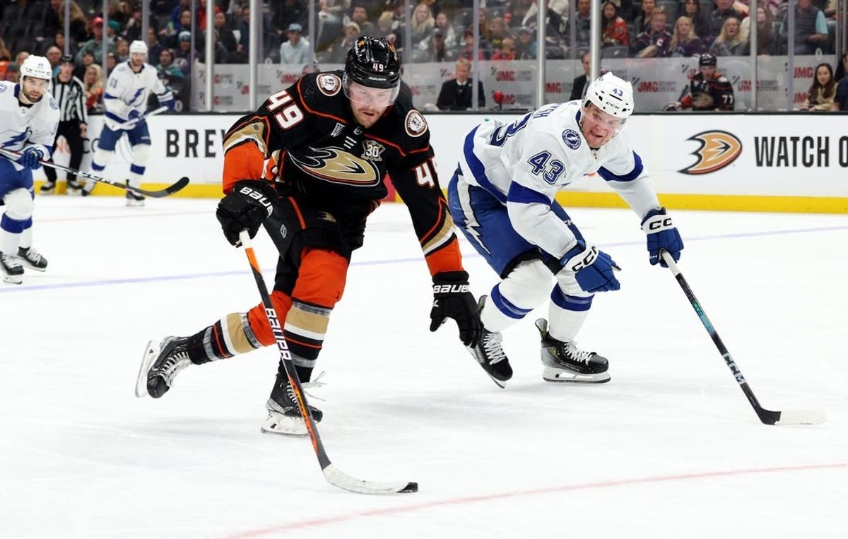 Mar 24, 2024; Anaheim, California, USA; Anaheim Ducks left wing Max Jones (49) keeps the puck from Tampa Bay Lightning defenseman Darren Raddysh (43) during the second period at Honda Center.