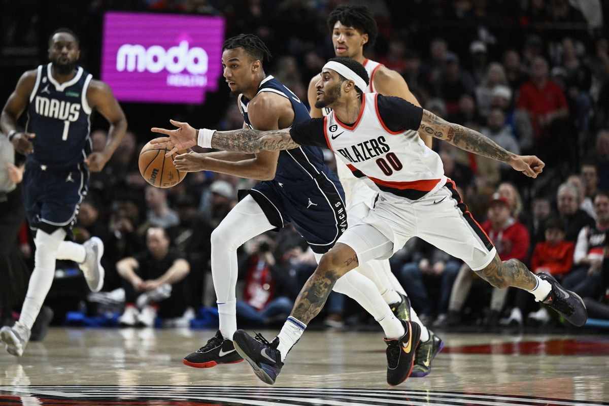 Jan 14, 2023; Portland, Oregon, USA; Portland Trail Blazers guard Gary Payton II (00) attempts to steal the basketball during the second half against Dallas Mavericks forward AJ Lawson (9) at Moda Center. Mandatory Credit: Troy Wayrynen-Imagn Images