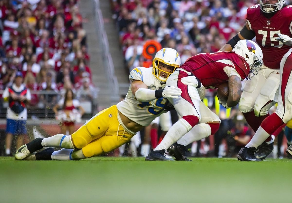 Nov 27, 2022; Glendale, AZ, USA; Arizona Cardinals running back James Connor (6) is tackled by Los Angeles Chargers linebacker Drue Tranquill (49) at State Farm Stadium. Mandatory Credit: Mark J. Rebilas-Imagn Images