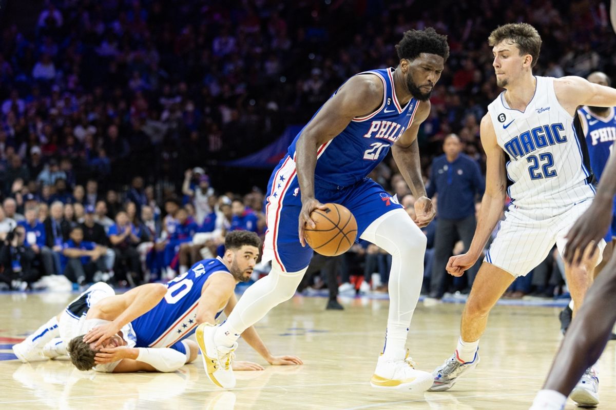 Philadelphia 76ers center Joel Embiid (21) dribbles the ball after a pass from Georges Niang (20) against Orlando Magic center Moritz Wagner (21) in front of forward Franz Wagner (22) during the fourth quarter at Wells Fargo Center. Mandatory Credit: Bill Streicher-Imagn Images