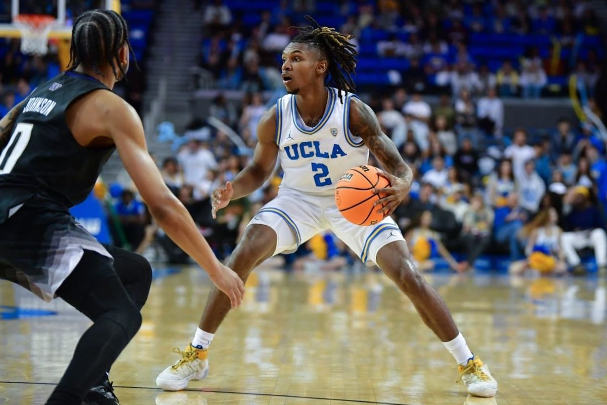 January 14, 2024; Los Angeles, California, USA; UCLA Bruins guard Dylan Andrews (2) controls the ball against Washington Huskies guard Koren Johnson (0) during the second half at Pauley Pavilion.