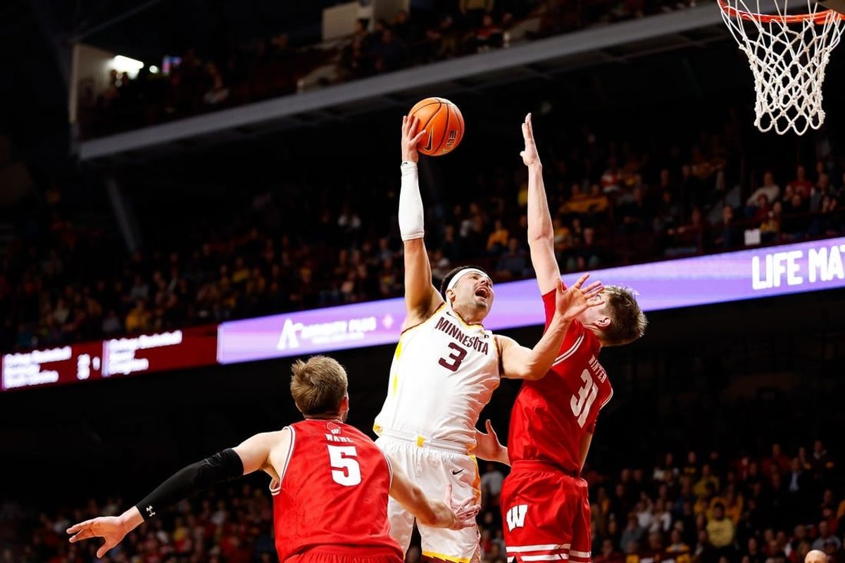 Jan 23, 2024; Minneapolis, Minnesota, USA; Minnesota Golden Gophers forward Dawson Garcia (3) shoots as Wisconsin Badgers forward Nolan Winter (31) defends during the first half at Williams Arena.