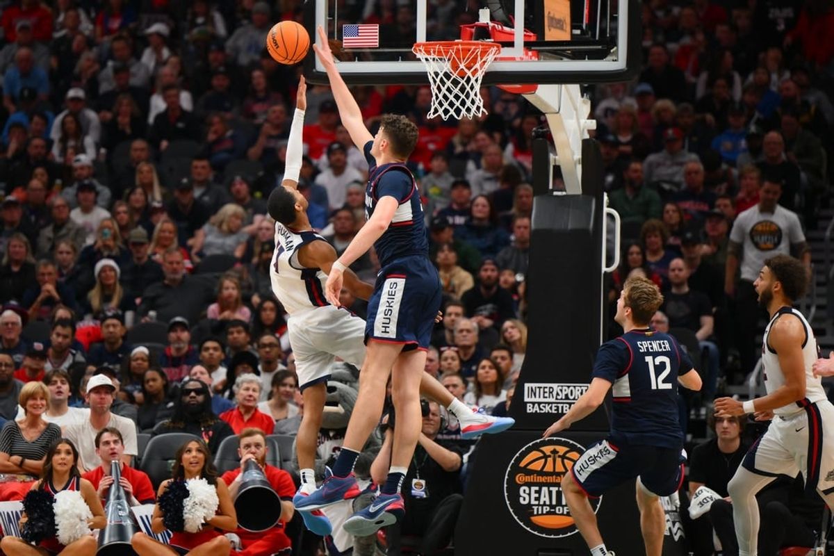 Dec 15, 2023; Seattle, Washington, USA; Connecticut Huskies center Donovan Clingan (32) blocks the shot attempt by Gonzaga Bulldogs guard Nolan Hickman (11) during the second half at Climate Pledge Arena.