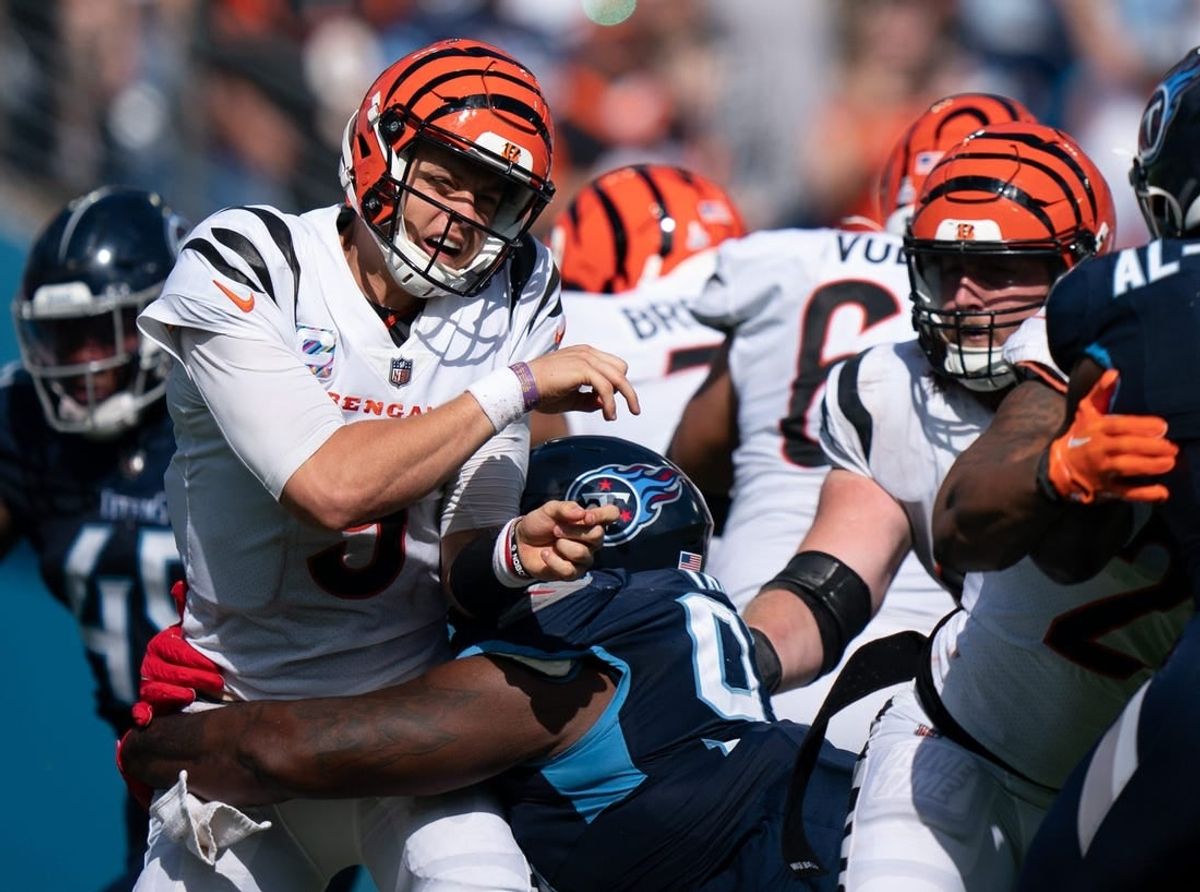 Cincinnati Bengals quarterback Joe Burrow (9) takes a hit by Tennessee Titans defensive tackle Teair Tart (93) in the fourth quarter at Nissan Stadium in Nashville, Tenn., Sunday, Oct. 1, 2023.