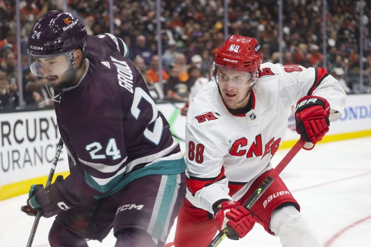 Oct 15, 2023; Anaheim, California, USA; Anaheim Ducks center Bo Groulx (24) makes a play against Carolina Hurricanes defensemen Brent Burns (8) in the third period at Honda Center.