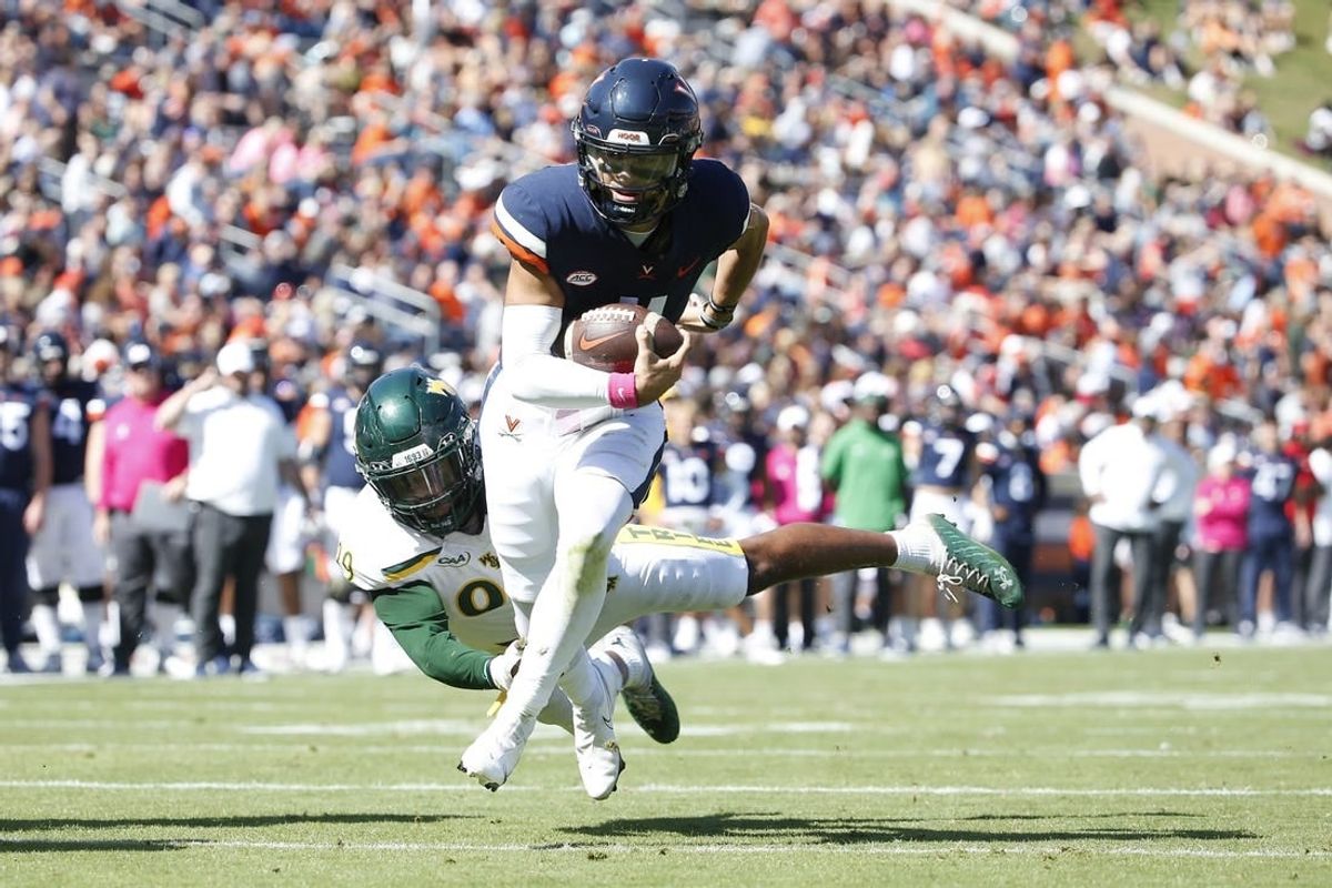 Oct 7, 2023; Charlottesville, Virginia, USA; Virginia Cavaliers quarterback Tony Muskett (11) scores a touchdown past William & Mary Tribe defensive lineman Nate Lynn (99) during the first half at Scott Stadium.