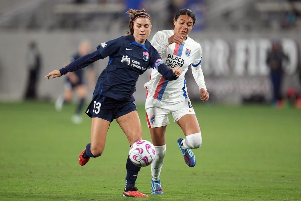 Nov 5, 2023; San Diego, California, USA;  San Diego Wave FC forward Alex Morgan (13) and OL Reign defender Alana Cook (4) battle for the ball in the second half at Snapdragon Stadium.