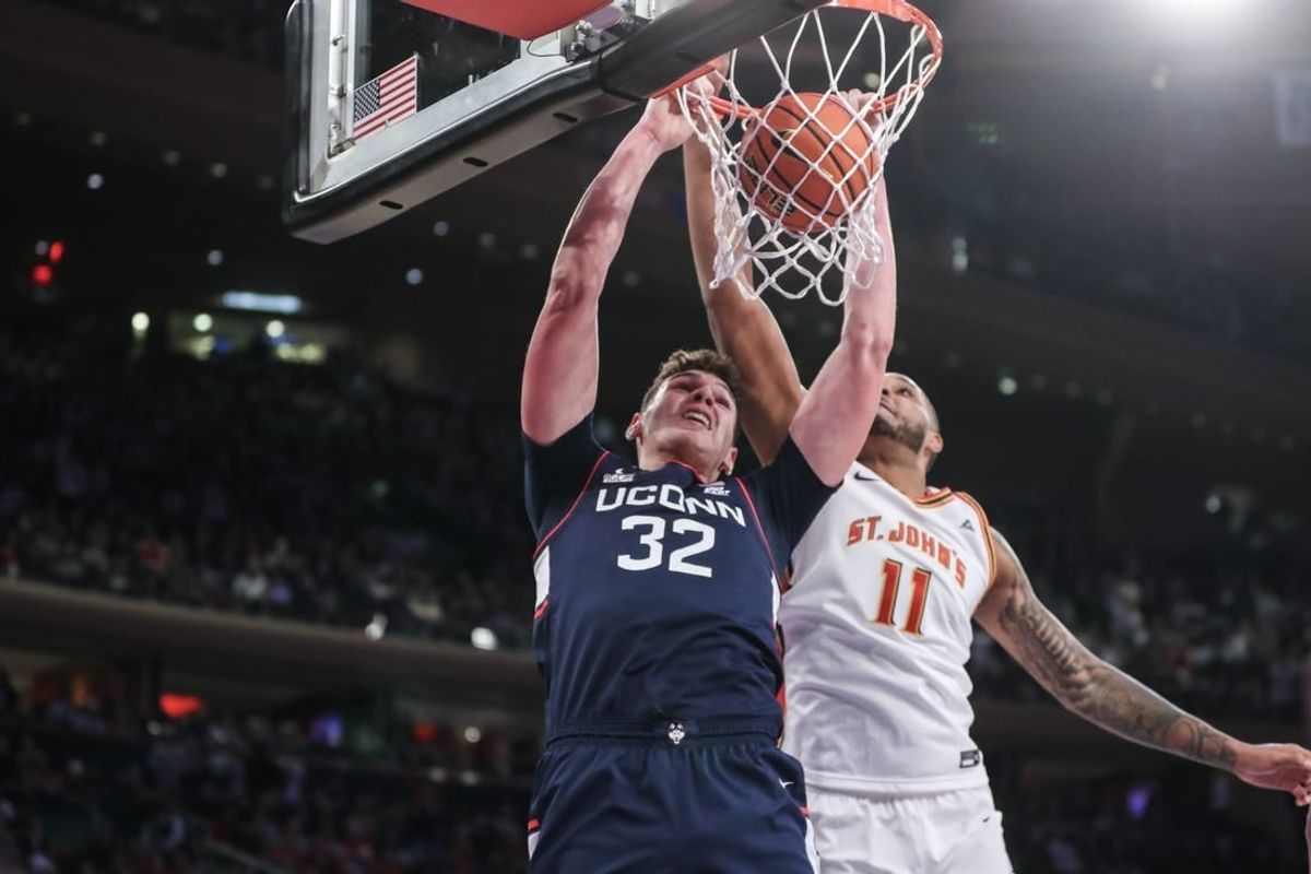 Feb 3, 2024; New York, New York, USA;  Connecticut Huskies center Donovan Clingan (32) dunks past St. John's Red Storm center Joel Soriano (11) in the first half at Madison Square Garden.