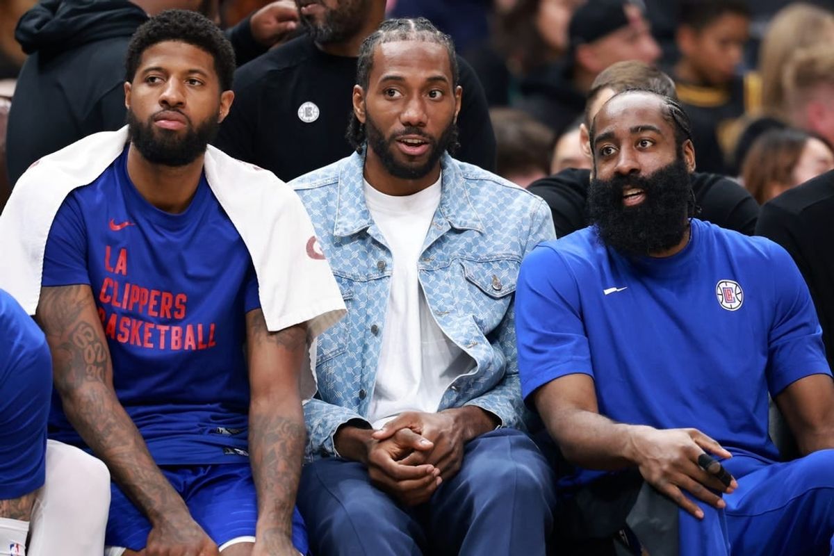 Apr 12, 2024; Los Angeles, California, USA;  Los Angeles Clippers forward Paul George (13, left) and forward Kawhi Leonard (2, center) and guard James Harden (1, right) watch the game from the bench during the third quarter against the Utah Jazz at Crypto.com Arena.