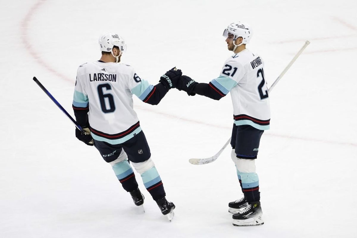 Nov 28, 2023; Chicago, Illinois, USA; Seattle Kraken center Alex Wennberg (21) celebrates with defenseman Adam Larsson (6) after scoring against the Chicago Blackhawks during the first period at United Center.