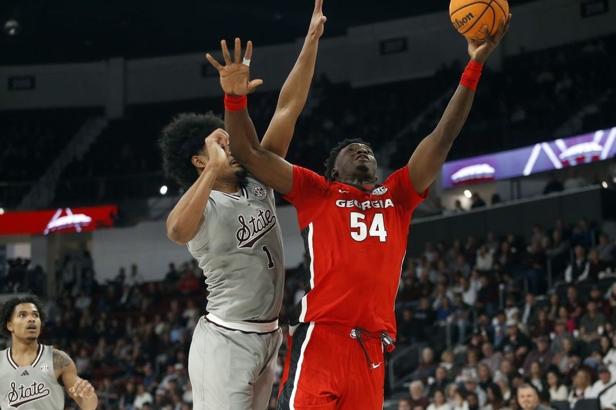 Feb 7, 2024; Starkville, Mississippi, USA; Georgia Bulldogs center Russel Tchewa (54) shoots as Mississippi State Bulldogs forward Tolu Smith (1) defends during the first half at Humphrey Coliseum.