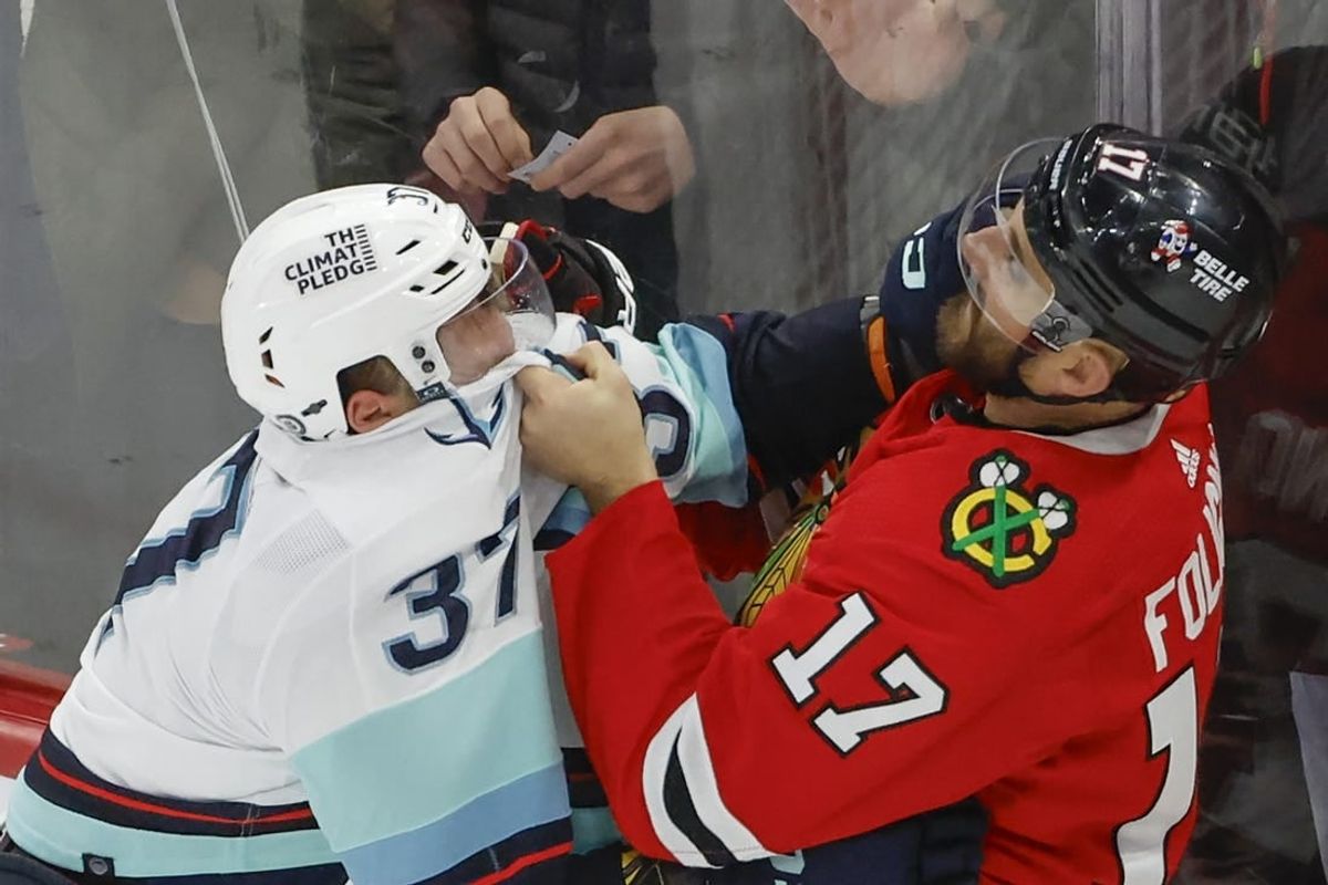 Nov 28, 2023; Chicago, Illinois, USA; Seattle Kraken center Yanni Gourde (37) fights with Chicago Blackhawks left wing Nick Foligno (17) during the second period at United Center.