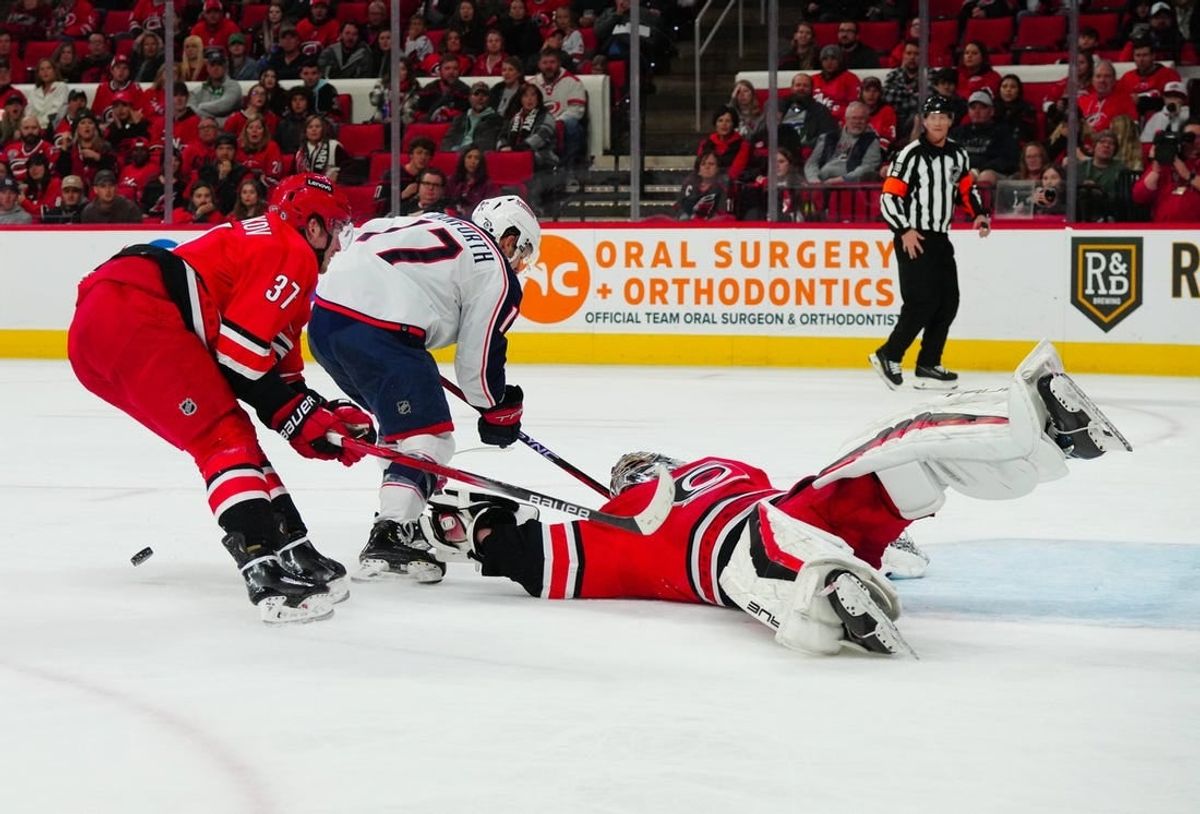 Nov 26, 2023; Raleigh, North Carolina, USA;  Carolina Hurricanes goaltender Pyotr Kochetkov (52) and right wing Andrei Svechnikov (37) stop the scoring attempt by Columbus Blue Jackets right wing Justin Danforth (17) during the second period at PNC Arena.