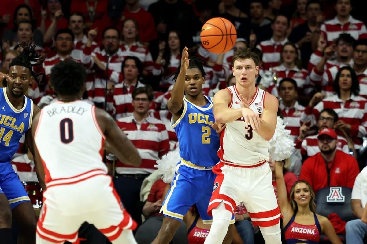 Jan 20, 2024; Tucson, Arizona, USA; Arizona Wildcats guard Pelle Larsson (3) makes a pass to guard Jaden Bradley (0) against UCLA Bruins guard Dylan Andrews (2) during the first half at McKale Center.